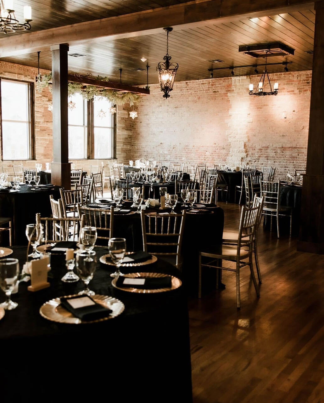 Long banquet table set with gold linens and floral centerpieces