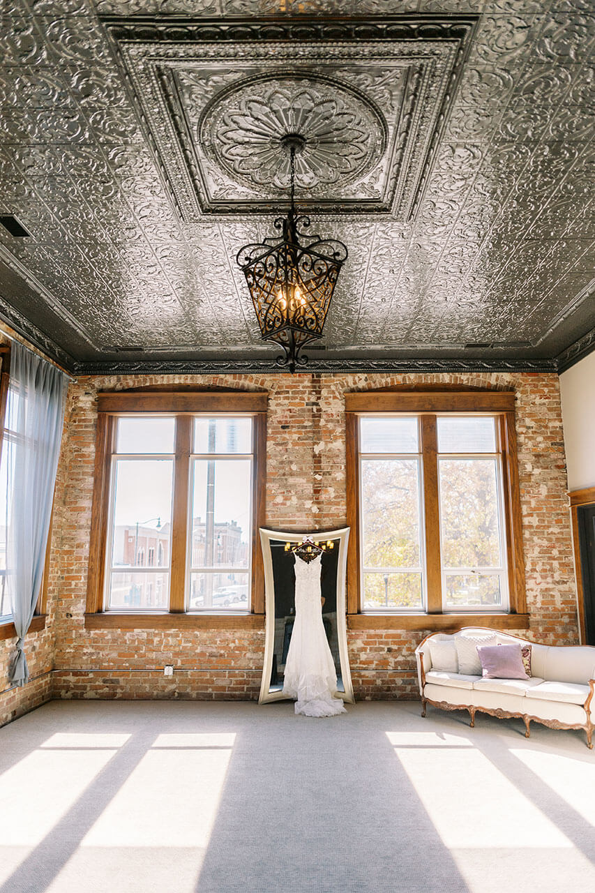 Wedding dress hanging in a sunlit bridal suite at The Gaderian