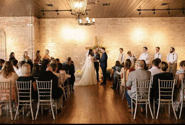 Indoor wedding ceremony with the couple exchanging vows at the altar