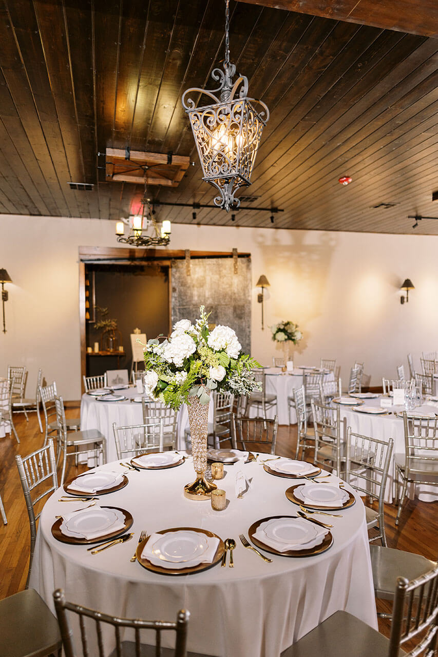 Floral arch and lanterns against exposed brick at The Gaderian