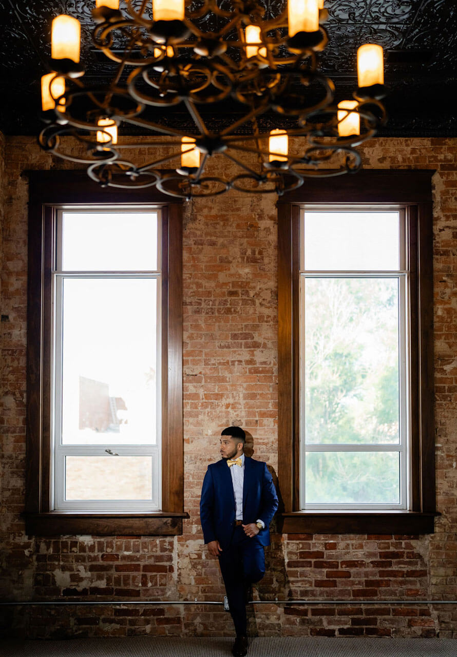 Long-exposure shot of couple kissing as guests move past on the rooftop