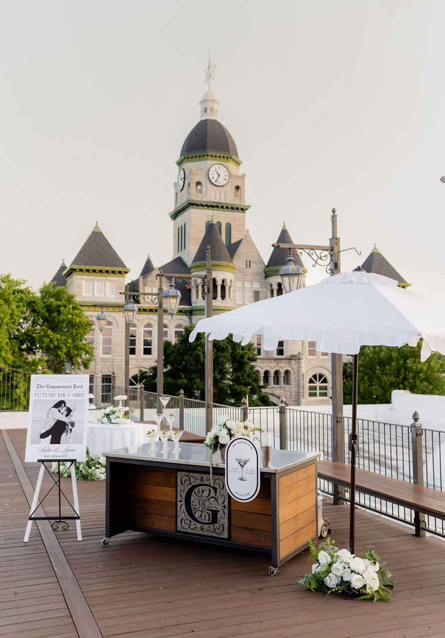 Rooftop cocktail tables with white linens and the courthouse beyond