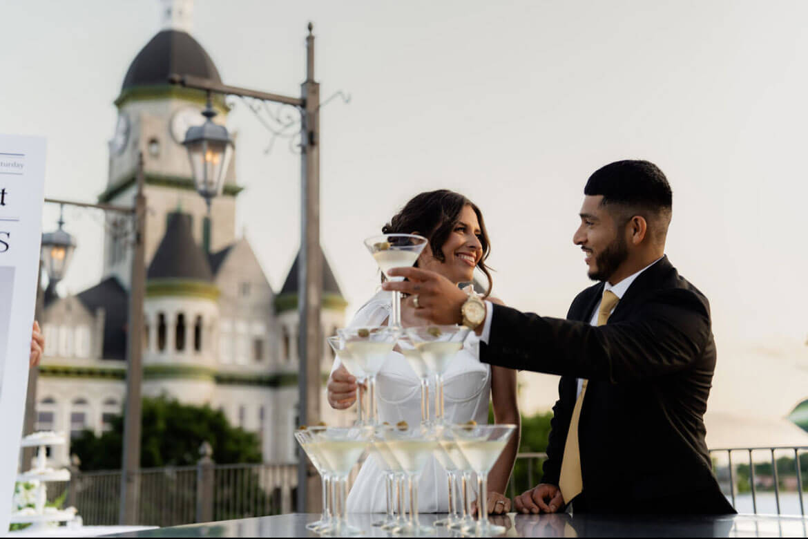 Bride and groom on The Gaderian rooftop at sunset with the Jasper County Courthouse behind them